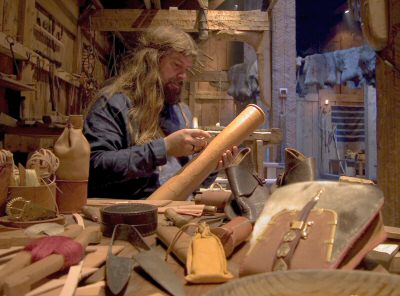 Gary Waidson demonstrating Viking age leather working techniques in the longhouse at Borg